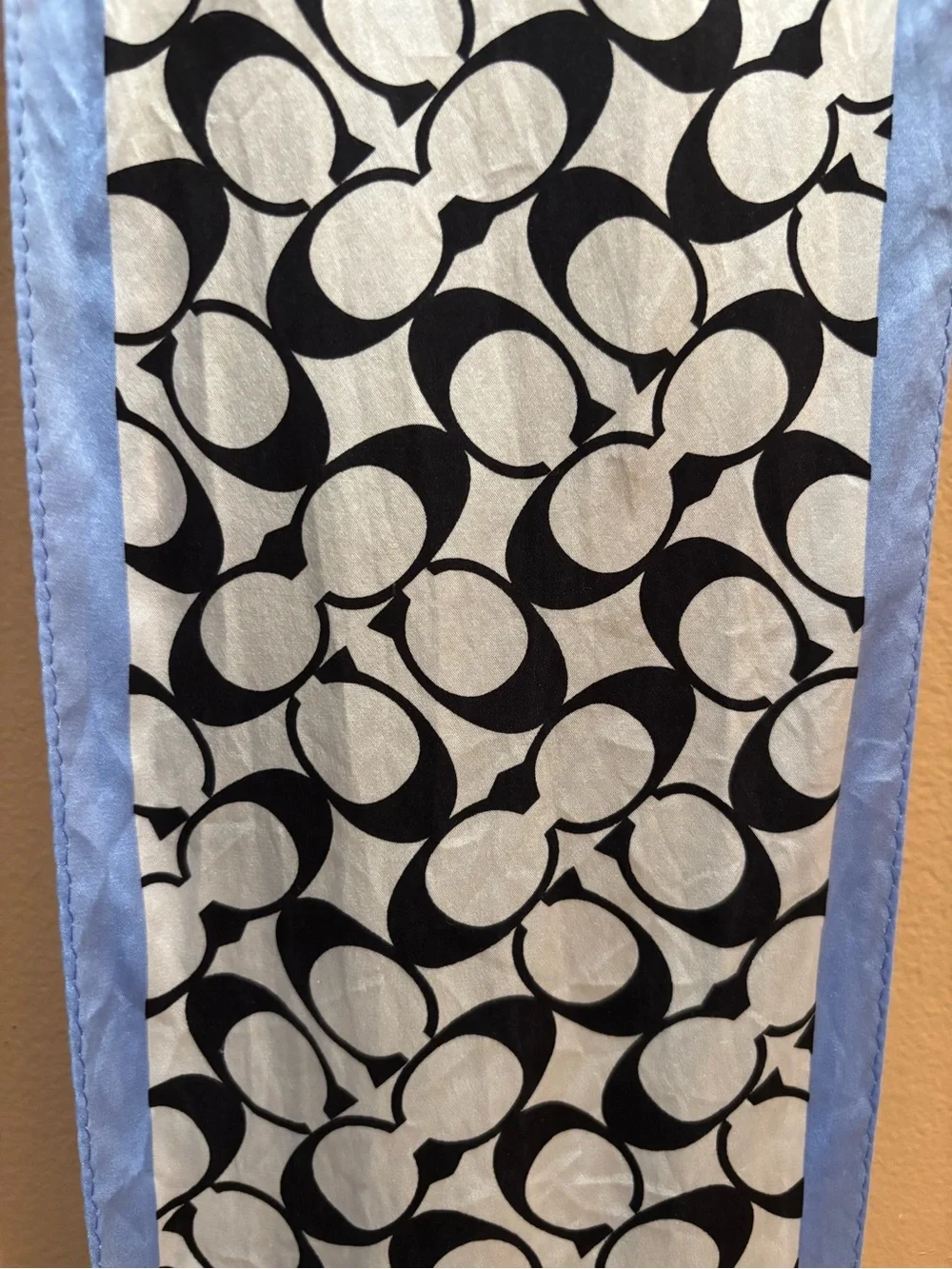 Coach scarf features the signature monogram print in black and white with light